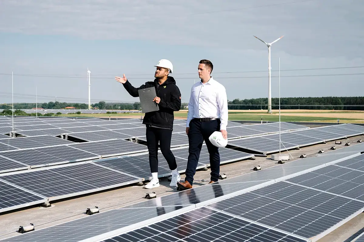 Zwei greenovative-Mitarbeiter laufen durch eine Dachanlage